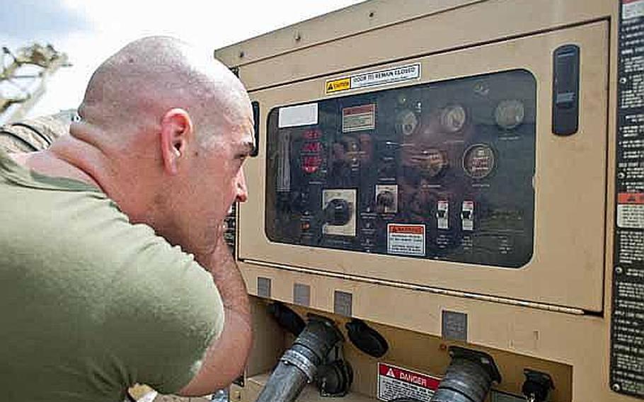 Marine Corps Capt. Jason Smith, the communications officer of Combat Logistics Regiment 35 out of Okinawa, Japan, cuts his hair using a generator control panel window as a mirror at the temporary camp set up at the Sendai Airport.