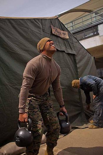 Gunnery Sgt. Eric Pate, the communications chief for Task Force Fuji lifts weights outside his work tent at the temporary U.S. Military camp set up at the Sendai Airport in Sendai, Japan. He said he works out every day.