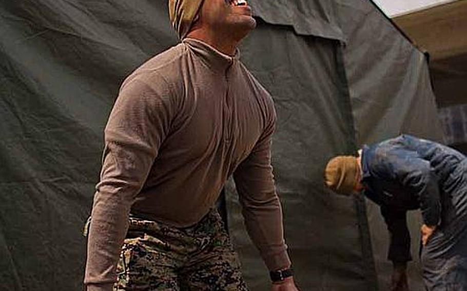 Gunnery Sgt. Eric Pate, the communications chief for Task Force Fuji lifts weights outside his work tent at the temporary U.S. Military camp set up at the Sendai Airport in Sendai, Japan. He said he works out every day.