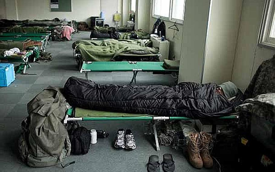 A soldier, along with Marines and troops from the Japan Self-Defense Force, sleeps in a male berthing at Camp Sendai, Japan. 