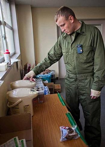 Marine Corps Sgt. Jesse Bramer, 26, with the Combat Assault Battalion out of Camp Schwab, Okinawa, pours hot water over cans of coffee to heat them at Camp Sendai, Japan.