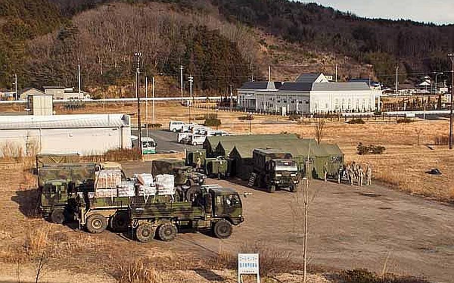 Soldiers begin to set up their new base of operations on the grounds of the Ishinomaki General Sports Park, in Ishinomaki, Japan, which Japan Self-Defense Force troops have already established as a main base for area troops. These soldiers along with almost 100 others are moving from their previous base at Sendai Airport, officials said.