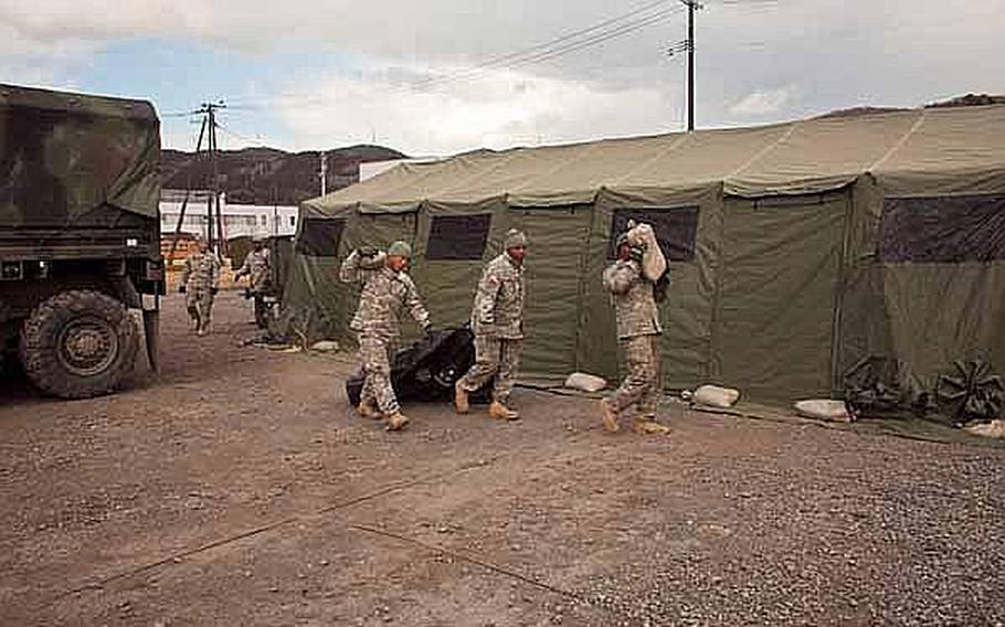 Soldiers begin to set up their new area base of operations on the grounds of the Ishinomaki General Sports Park, in Ishinomaki, Japan.The soldiers, along with almost 100 others, are moving from their previous base at Sendai Airport.