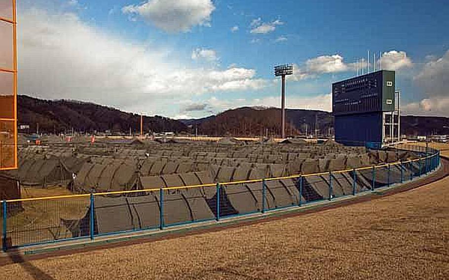 Japan Self Defense Force tents fill the outfield of Ishinomaki General Sports Park in Ishinomaki, Japan, which has become the base of operations for the area. Approximately 100 U.S. Army soldiers moved from their camp at Sendai Airport to the stadium grounds.