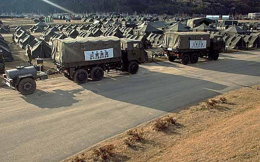 Japan Self-Defense Force vehicles and tents have taken over the Ishinomaki General Sports Park in Ishinomaki, Japan, which has become their base of operations for the area. Approximately 100 U.S. Army soldiers moved from their camp at Sendai Airport to the stadium grounds.