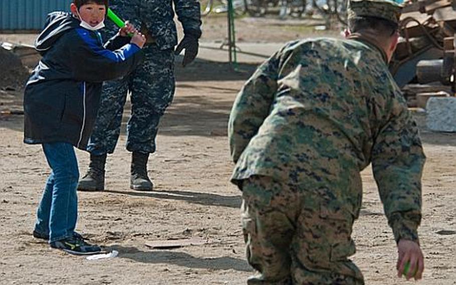 U.S. troops from Okinawa and Camp Fuji play baseball with children at the Watanoha Elementary School shelter in Ishinomaki, Japan, after helping clean up the school grounds as well as deliver aid provided by the Christian relief organization Samaritan's Purse. The U.S. military has also been coordinating with other NGOs to deliver aid, officials said.