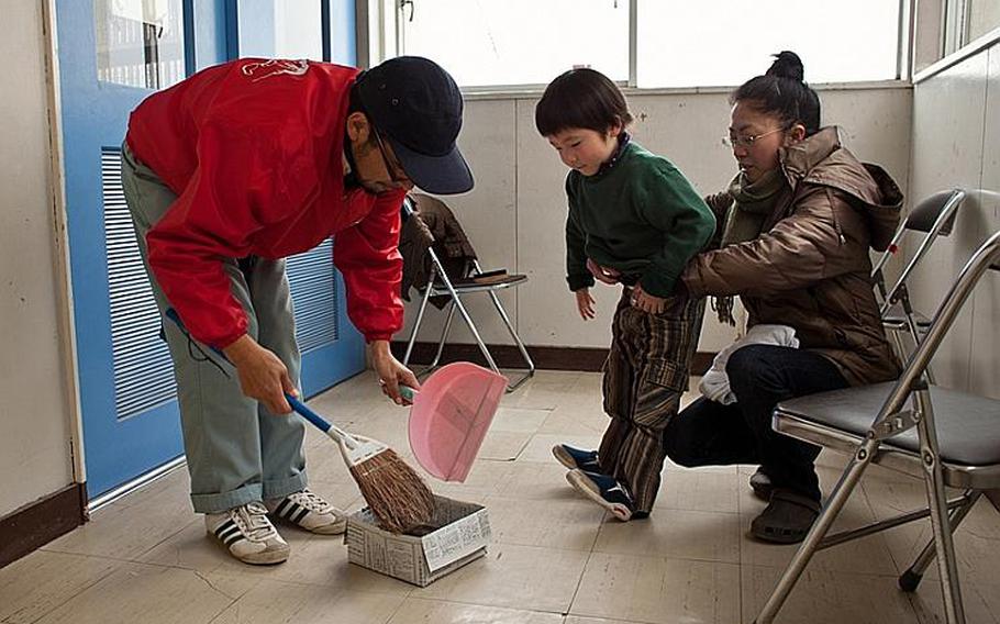 Takeshi Nakagawa and wife Chikako clean up after cutting their son Sota's hair at the Kadonowaki Middle School shelter in Ishinomaki, Japan. The shelter said all displaced residents of the school's classrooms must clear out by the beginning of the new school year on April 21.