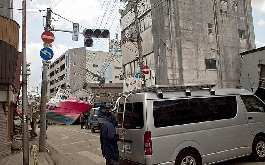 A boat, brought inland during the March 11 tsunami, lies in an Ishinomaki street on Monday.