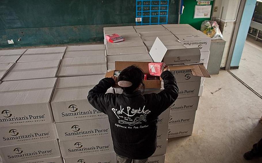 A volunteer goes through a box of personal care items provided by the Christian relief organization Samaritan&#39;s Purse that were delivered to the Watanoha Elementary School shelter with the help of the Marine Corps.