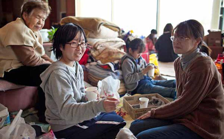 Fumika Itabashi, 13, left, sitting at the Tagajo Culture Center with her mother, Keiko, shelter explains what happened during the aftershock that struck Japan the night before.