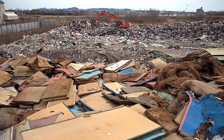 A mound of thousands of waterlogged tatami mats sits at the edge of one of two massive dump sites set up to store tsunami-related trash in Ishinomaki, Japan.