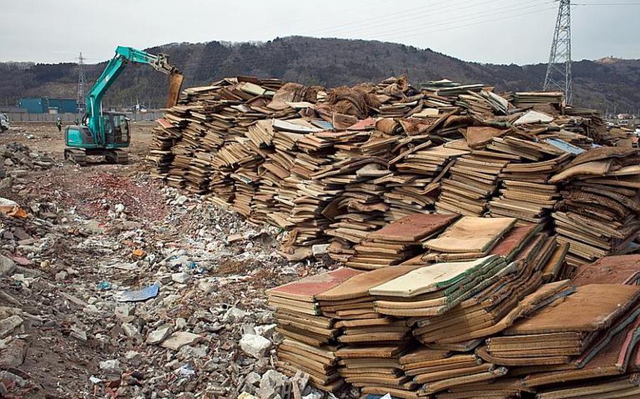 A mound of thousands of waterlogged tatami mats sits at the edge of one of two massive dump sites set up to store tsunami-related trash in Ishinomaki, Japan.