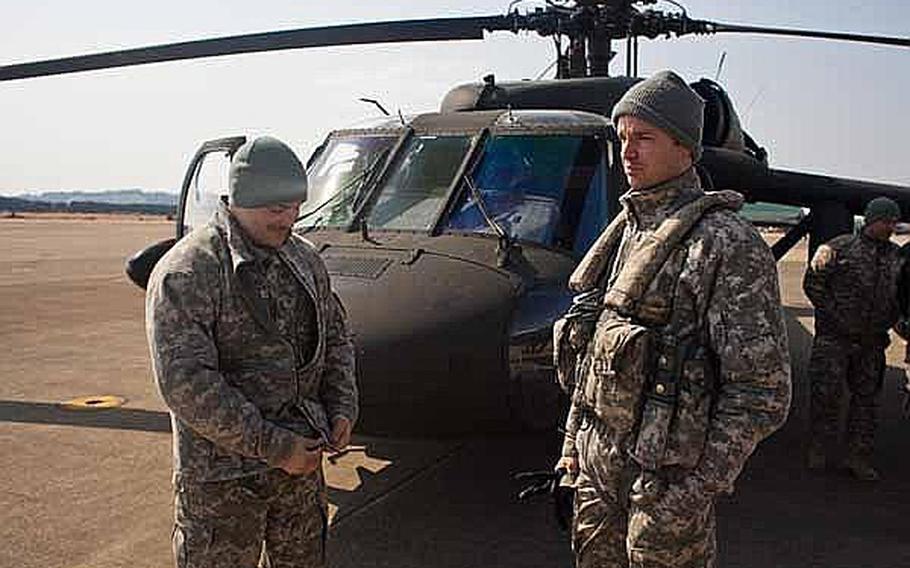 Two U.S. Army UH-60 Black Hawk pilots talk after flying a mission to Ishinomaki, Japan, at Matsushima Air Base in Higashimatsushima, Japan.