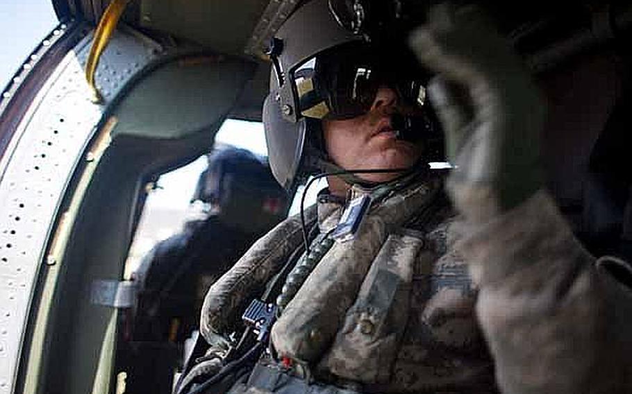 Army Sgt. 1st Class Scott Newhart, a UH-60 crew chief, motions to his other crew member prior to lifting off from Ishinomaki, Japan. Two UH-60s from Camp Zama-based U.S. Army Aviation Detachment Japan, along with two fixed-wing aircraft from Naval Air Facility Atsugi, have transported personnel and supplies in support of relief efforts in the region since March 18.