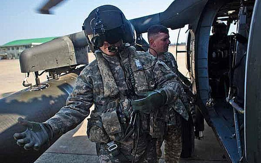 Army Sgt. 1st Class Scott Newhart, a UH-60 crew chief, assists passengers with their gear at Matsushima Air Base in Higashimatsushima, Japan, prior to a personnel transport flight to Ishinomaki, Japan.