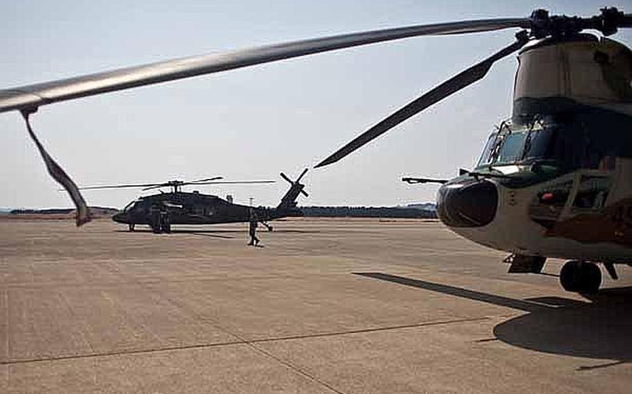 A UH-60 Black Hawk helicopters sits behind a Japan Self Defense Force helicopter at Matsushima Air Field in Matsushima, Japan. Two UH-60s from Camp Zama-based U.S. Army Aviation Detachment Japan, along with two fixed-wing aircraft from Naval Air Facility Atsugi, have transported personnel and supplies in support of relief efforts in the region since March 18.