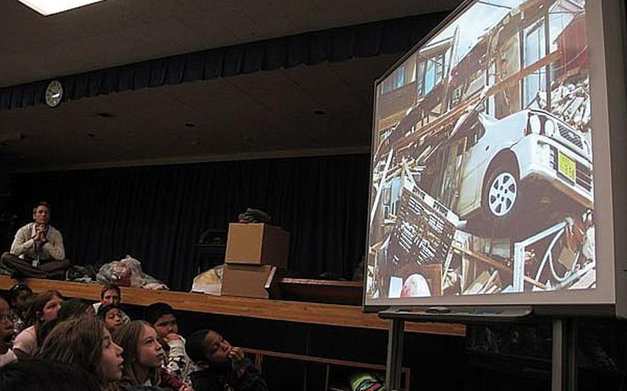 Fourth grade and fifth grade students at Yokosuka Naval Base's Sullivans School in Japan view photos taken by a local teacher recently of the damage wrought by the March 11 earthquake and tsunami near Sendai. Educators at base schools in Japan say they must walk a fine line by teaching students about the disaster, but not increasing their anxieties.