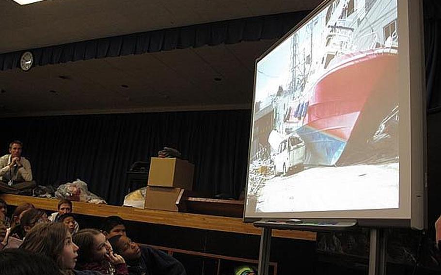 Fourth grade and fifth grade students at Yokosuka Naval Base&#39;s Sullivans School in Japan view photos taken by a local teacher recently of the damage wrought by the March 11 earthquake and tsunami near Sendai. Educators at base schools in Japan say they must walk a fine line by teaching students about the disaster, but not increasing their anxieties.