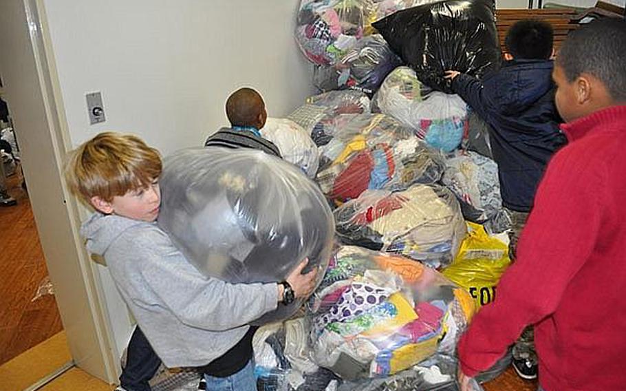 Owen Williams, a 5th grade student at Yokosuka Naval Base's Sullivans School in Japan, carries winter clothing for donation to the victims of the March 11 earthquake and tsunami. Educators at U.S. military base schools in Japan say they must walk a fine line by teaching students about the disaster, but not increasing their anxieties.