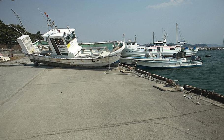 A fishing boat, washed ashore during the March 11 tsunami, sits on a pier at a harbor in Matsushima, Japan.
