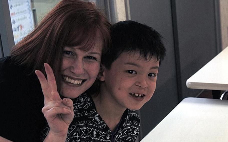 Gemini Sanford poses with one of the orphans at the Bikou-en Children's Care House in Shichinohe, Japan. Sanford has spearheaded efforts from Naval Air Facility Misawa, Japan, to bring food and supplies to the children following a March 11 earthquake.