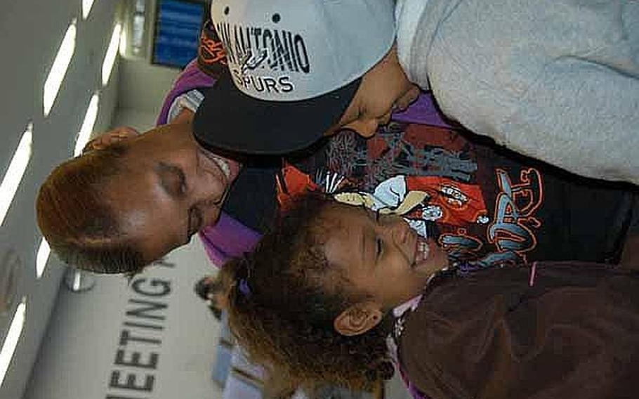 Army Spc. Tina Johnson, 37, got big hugs from her daughter, Leilani, 7, and son, Nehemiah, 10, when she welcomed them back to Narita Airport, Japan, on Friday. 