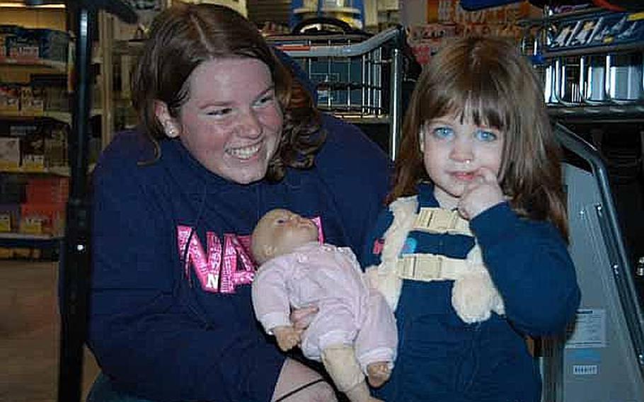 Emily Dibble, 2, holds her doll as she and mother Candace waits for a bus to Yokosuka Naval Base. The Dibbles were among thousands of family members who left Japan following the March 11 earthquake and are now returning now that the Defense Department is ending its voluntary departure program.