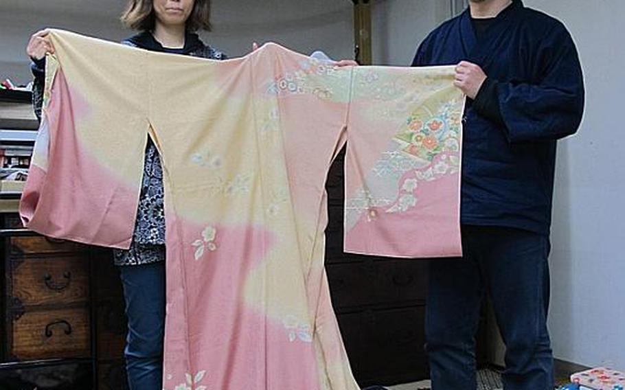 Hiromi Hayashi and her husband, Takatoshi, display a kimono at their shop near Ishinomaki train station Friday. The Hayashi family&#39;s store is the only kimono shop open in Ishinomaki, where thousands perished in the 55-foot tsunami that struck following the March 11 earthquake. Although wearing a kimono now would be considered inappropriate, the Hayashis are doing business by cleaning customer kimonos that were soiled by the muck brought ashore in the tsunami&#39;s wake.