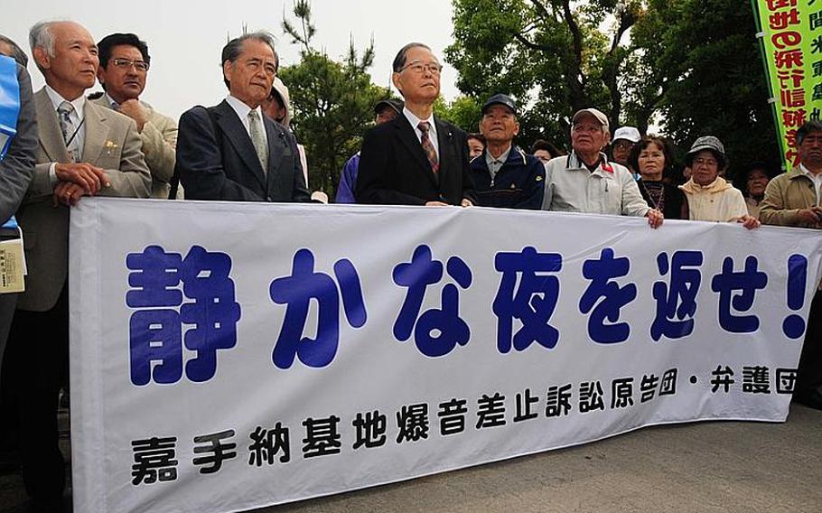 Okinawans rally Thursday in front of Okinawa City branch of the Naha District Court, prior to filing a lawsuit against Japanese government over aircraft noise from Kadena Air Base.