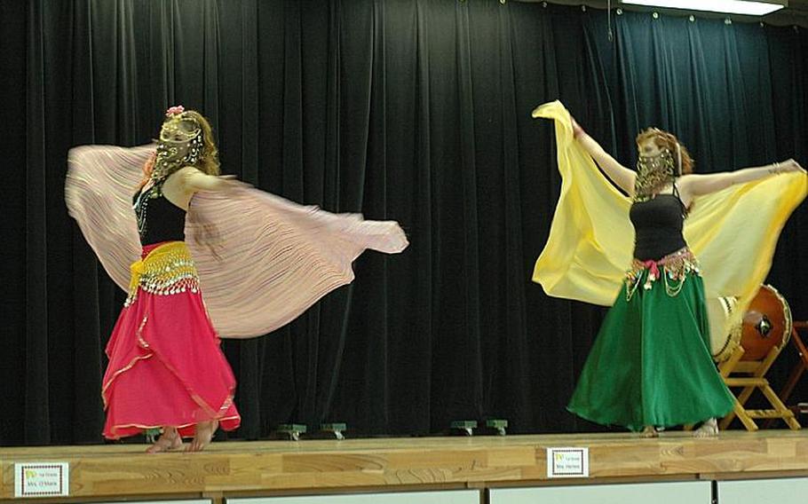 Kazuko Igarashi, left, and Karmen Kincaid put on a belly-dancing demonstration, shaking and shimmying through a set of songs in different costumes on Saturday during an intermission in a Dragon-Eagle Taiko drum team performance at Misawa Air Base, Japan.