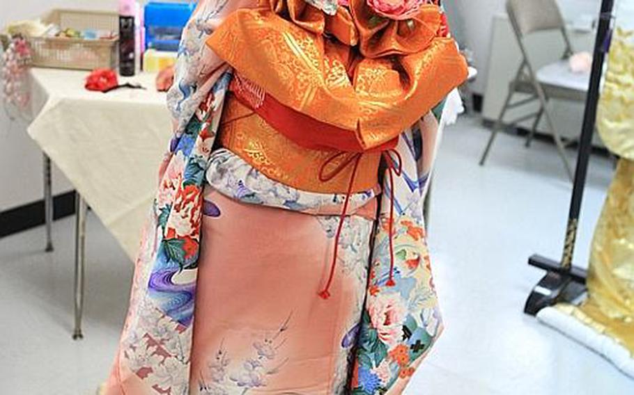 Samantha McCraken, a 10-year-old at Joan K. Mendel Elementary School fashions a traditional Japanese kimono Tuesday for Japan-Asia Day.