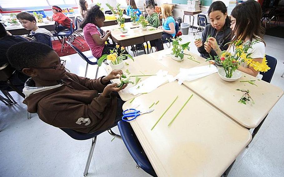 Fifth-gradersJennifer Shoup (right) Alicia Morgan and Chris Pegram learn the art of Ikebana - the Japanese art of flower arrangement for Japan-Asia Day at Joan K. Mendel Elementary School on Tuesday.