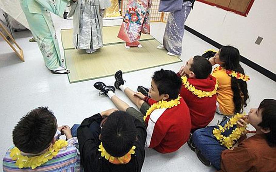 Kimono school teachers from Hamura City show fifth-graders Spencer Mack and Samantha McCraken from Joan K. Mendel Elementary School how to wear kimono during their Japan-Asia Day celebration Tuesday.