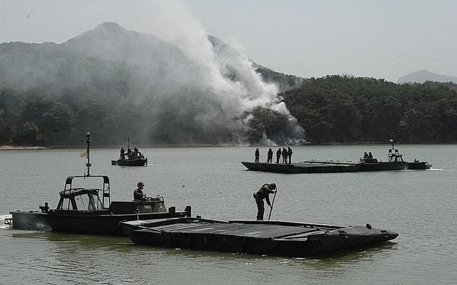 Soldiers bring together segments of a pontoon bridge, which was then used to ferry Bradleys during an exercise Tuesday in Cheorwon, South Korea. The exercise allowed the U.S. and South Korean militaries to practice moving manpower and equipment across lakes, rivers and streams.