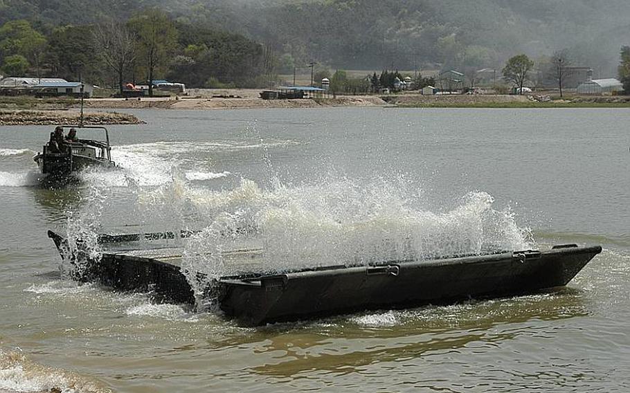 A section of a pontoon bridge springs open after being dropped into a pond during a joint U.S.-South Korean military exercise Tuesday near the Demilitarized Zone. Sections of a bridge were put together and then used to simulate the ferrying of Bradleys across a lake, river or stream.