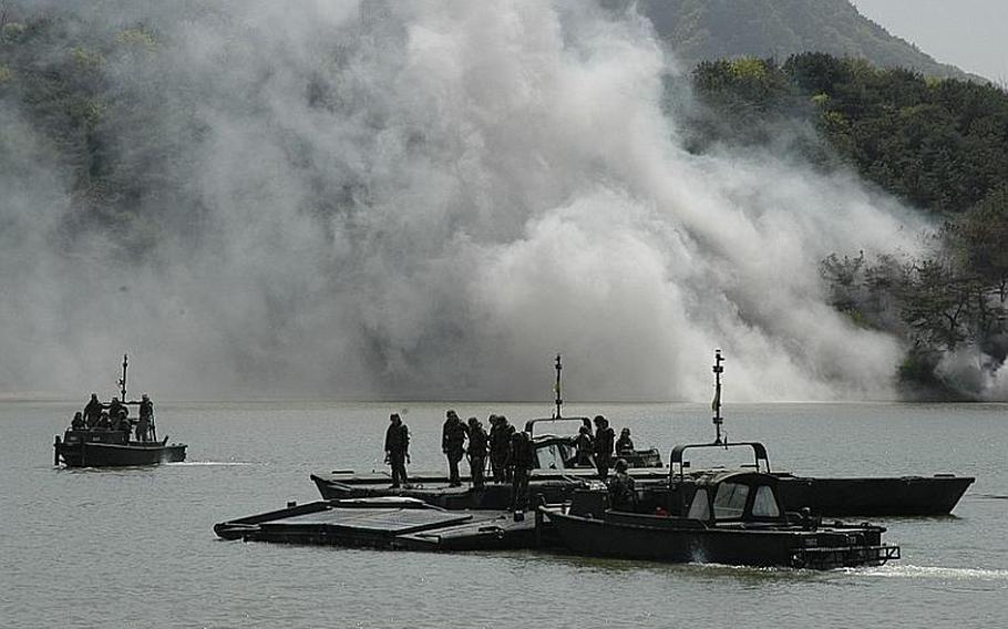 Soldiers bring together segments of a pontoon bridge, which was then used to ferry Bradleys during an exercise Tuesday in Cheorwon, South Korea. The exercise allowed the U.S. and South Korean militaries to practice moving manpower and equipment across lakes, rivers and streams.