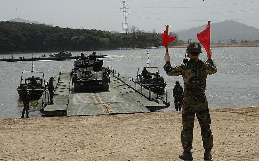 A Bradley is driven off a pontoon bridge Tuesday during a joint U.S.-South Korean military exercise near the Demilitarized Zone. The bridge was used to simulate the ferrying of manpower and equipment across a lake, river  or stream.