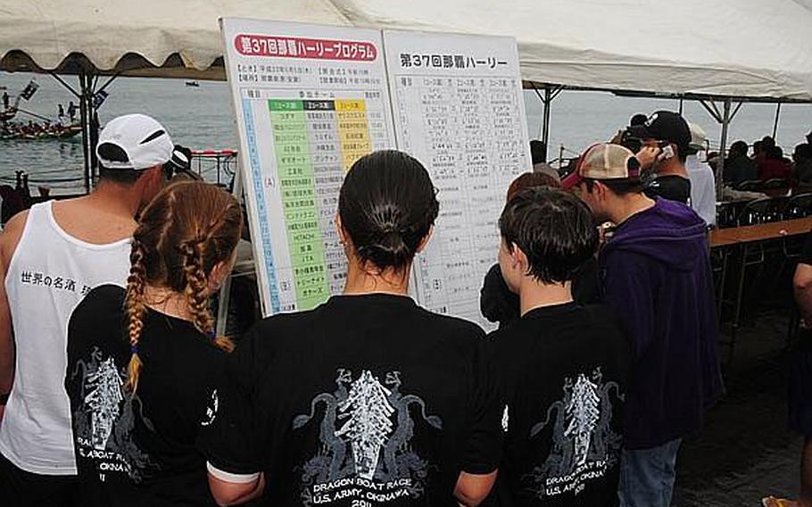 Members of the female Army dragon boat team look at their official time on the time board. The team crossed the finish line in 6 minutes and 19 seconds, placing second in their heat, beating an all-male team and beating their 2010 time by about 20 seconds.