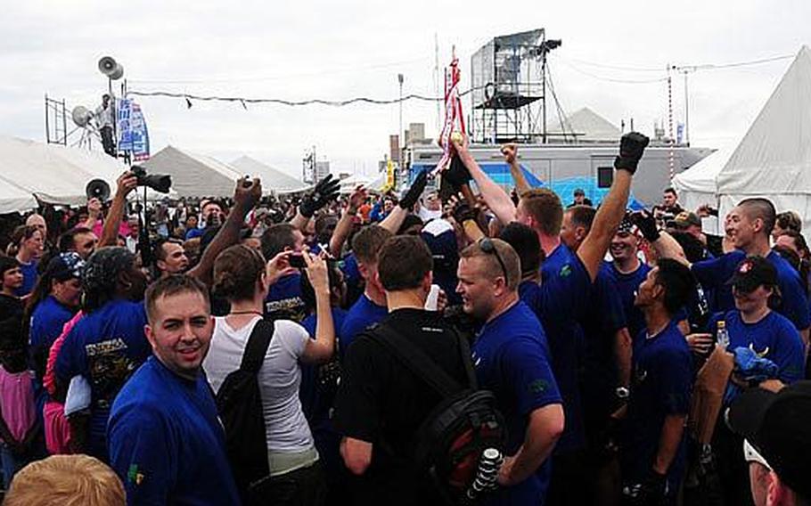 Members of the male Air Force Dragon Boat team loft their trophy into the air and celebrate after finishing first in their heat. They narrowly beat out the Army team, who came in just three seconds behind them. Winners of each heat received a trophy.