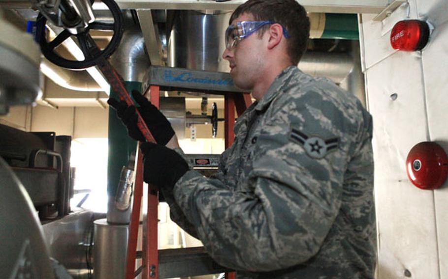 Airman 1st Class Matthew Ewing, a heating and ventilation technician from the 374th Civil Engineer Squadron, works on the chill water valve for an air conditioning unit to help with energy saving measures Friday on Yokota Air Base, Japan.