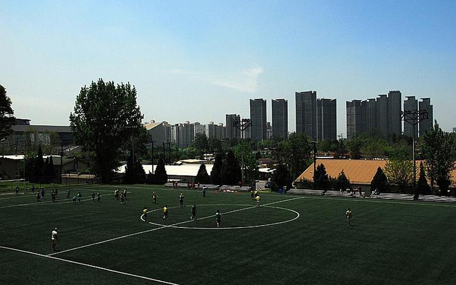 Students play soccer on a field at U.S. Army Garrison-Yongsan, with high-rise apartments in the neighboring Ichon-dong district in the background. A government ministry recently announced plans to turn Yongsan into six connected parks after the base returns to South Korean control later this decade.