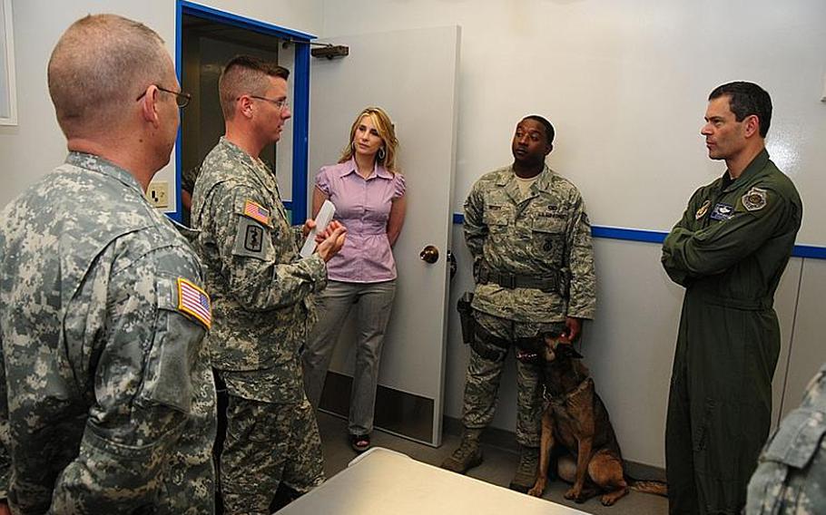 Maj. Kent Vince, Chief, Okinawa Branch, Japan District Veterinary Command, second from left, explains some of the new equipment and benefits of the newly renovated Okinawa Veterinary Treatment Facility to Brig. Gen. Kenneth S. Wilsbach, 18th Wing Commander, Kadena Air Base, right, during an open house in April to allow the public to see the new facility before it officially opened Wednesday.