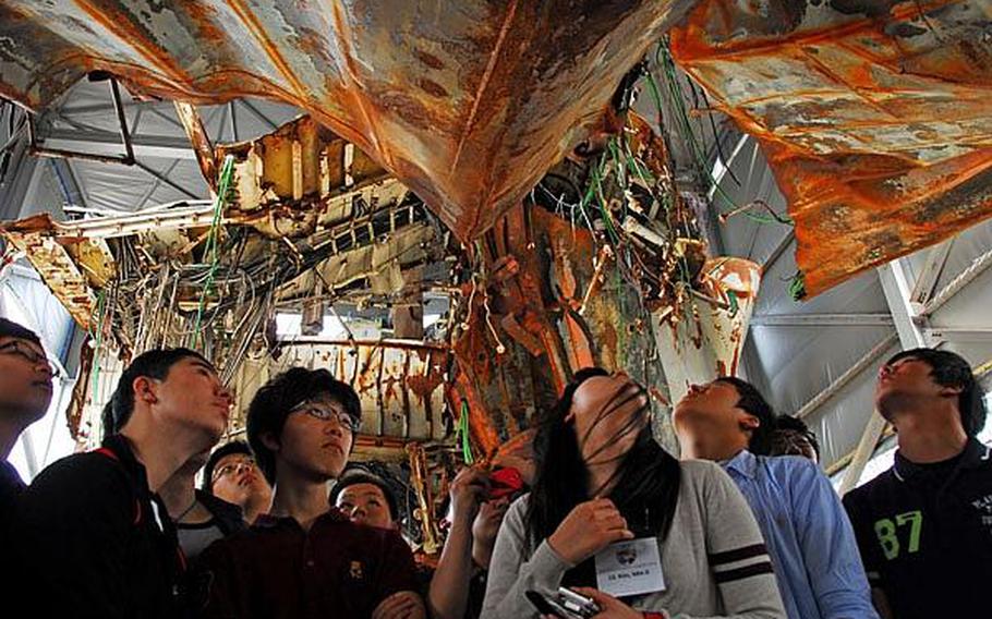 Participants in the Good Neighbor English Camp look Wednesday at the wreckage of the Cheonan, the South Korean ship hit last year by a North Korean torpedo. Sixty-six South Korean teenagers participated in the week-long camp.