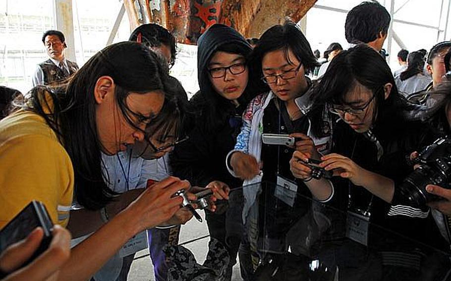 South Korean students take photos of a replica of the torpedo that sank the Cheonan, a South Korean warship on patrol near North Korean waters, in March 2010. The students participated this week in U.S. Forces Korea's Good Neighbor English Camp, a week-long cultural immersion program in which students live with military families and visit U.S. bases and other sites.