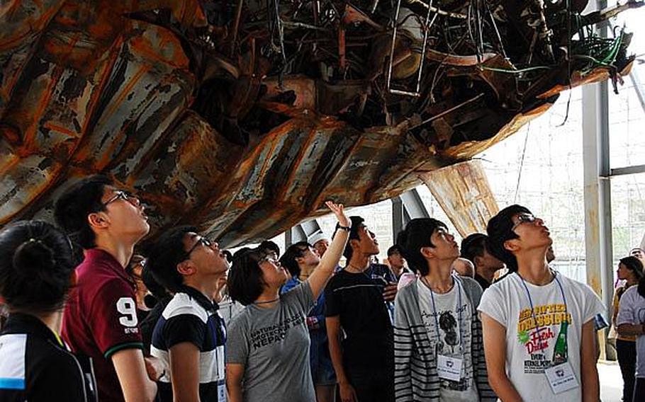 Participants in the Good Neighbor English Camp look Wednesday at the wreckage of the Cheonan, the South Korean ship hit last year by a North Korean torpedo. Sixty-six South Korean teenagers participated in the weeklong camp.