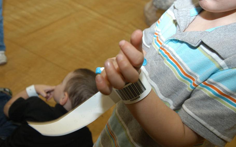 Three-year-old Christian Gasper shows off a noncombatant evacuation operation tracking bracelet put on his wrist during an evacuation exercise Thursday at Camp Red Cloud is South Korea. The bracelets would be used to track the progress of evacuees as they are moved off the peninsula in the event of an evacuation prompted by a North Korean attack.