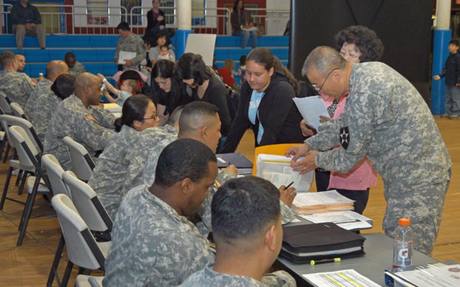 U.S. military dependents are processed through a variety of stations during the Courageous Channel evacuation exercise Thursday at Camp Red Cloud in South Korea.