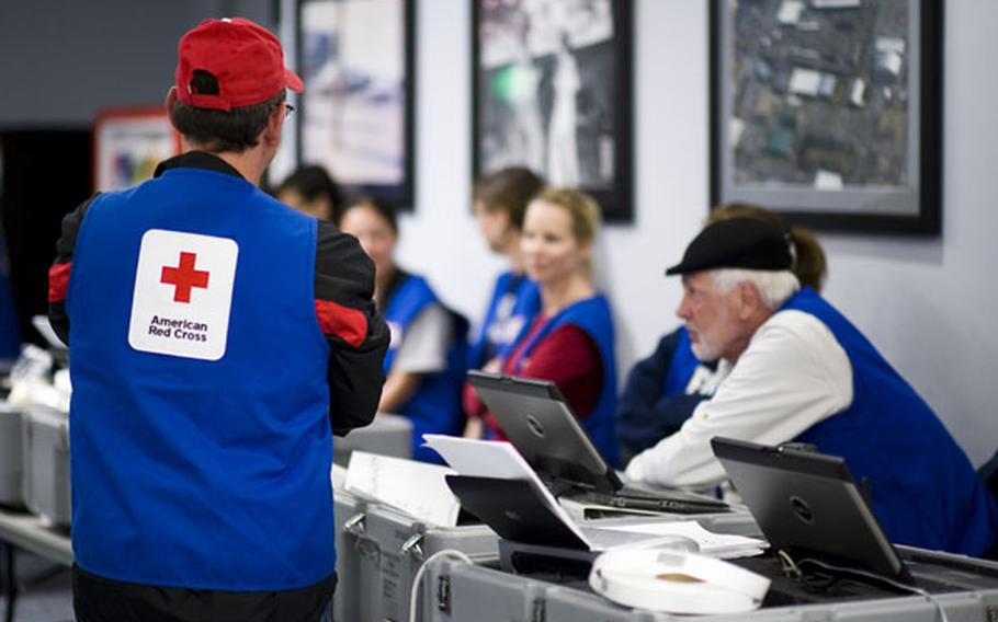 Red Cross volunteers stand by to help with out-processing of military dependents at Yokota Air Base, Japan, on March 19. 