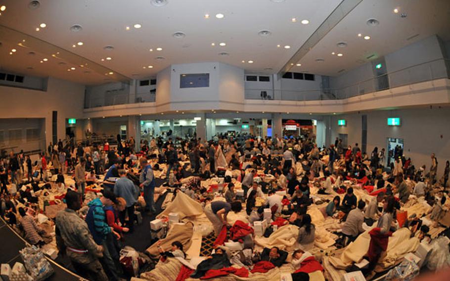 Delta Air Lines passengers take shelter inside the Taiyo Community Center at Yokota Air Base, Japan, on March 11. American Red Cross volunteers provided blankets, pillows, food and water for aircraft passengers whose planes were diverted from Narita International Airport following an earthquake in northern Japan.