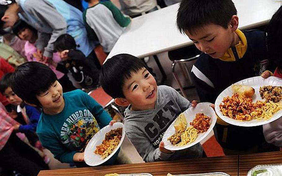 Children at Bikou-en Children's Care House wait in line for a home-cooked meal delivered March 27 by sailors from Naval Air Facility Misawa.